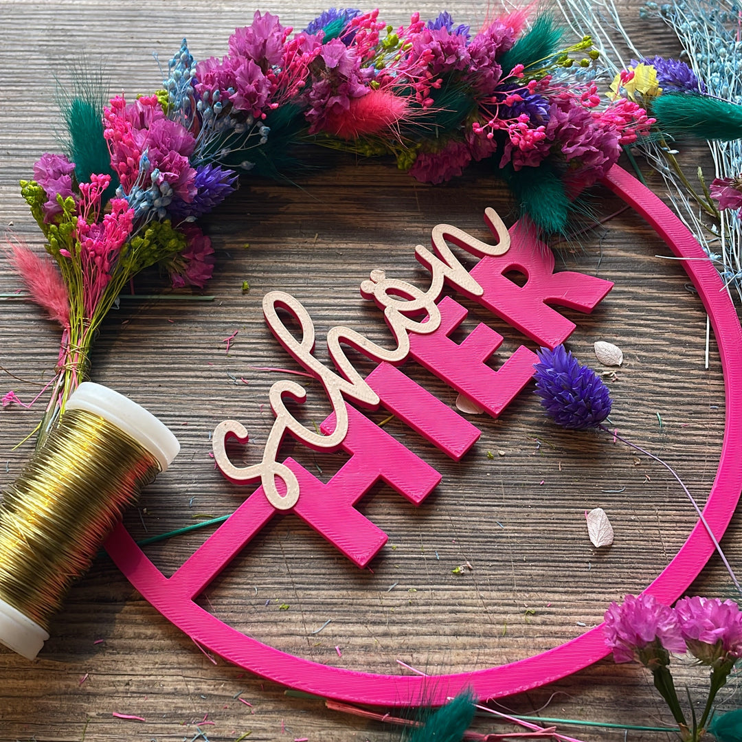 3d gedruckter Kranz liegt auf Arbeitsplatz leicht umwickelt mit Trockenblumen. Detailbild des Arbeitsvorgangs im Blumneladen